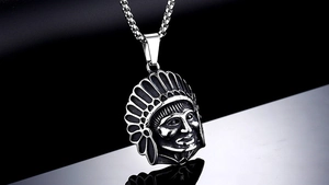 Macro close-up of a silver vintage steel Native American chief pendant with feathers