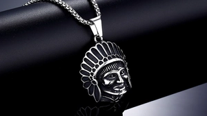 Macro shot of silver vintage Indian chief head pendant with intricate feather details