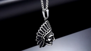 Detailed macro view of vintage Indian chief pendant in aged steel with box chain