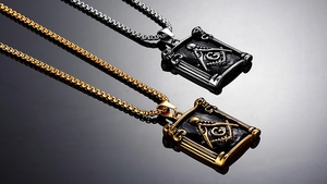 Macro shot of gold and silver Masonic necklaces featuring rectangle pendants with skull details