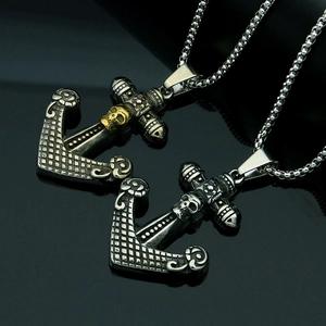 Detail of vintage anchor and skull pendants with retro punk style in black silver finish