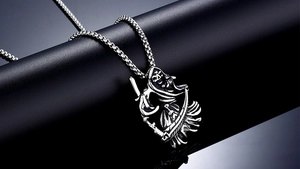 Macro detail of Grim Reaper pendant in vintage steel with scythe on jewelry stand