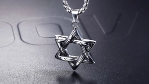 Makroaufnahme des silbernen Hexagramm-Anhängers aus Edelstahl mit Webstruktur