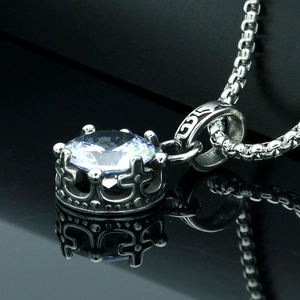 Vintage silver crown necklace with a brilliant round-cut gemstone on a black mirror surface