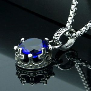 Elegant crown pendant necklace with deep blue gemstone on a polished silver box chain