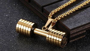 Vue macro du pendentif haltère en acier inoxydable doré avec lettrage GO FIT gravé