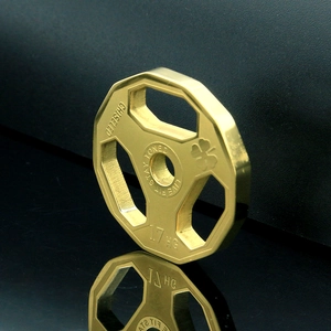 Macro shot of gold dumbbell plate pendant with engraved live fit stay toned text and clover