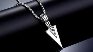 Macro detail of silver stainless steel arrowhead pendant on a round box chain