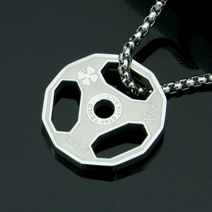 Macro detail of hexagonal fitness weight plate pendant with motivational engravings