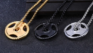 Detail of barbell plate necklaces in gold, black, and silver finishes with 45 LBS engraving