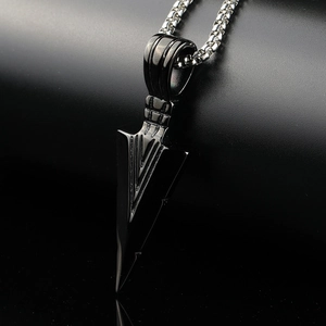 Macro shot of black arrow pendant featuring V-shaped lines and silver box chain detail