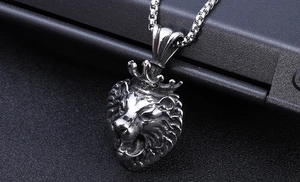 Gros plan du pendentif lion couronné en argent avec sa chaîne maille vénitienne