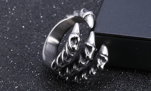 Detailed macro view of a dragon claw ring with a brushed metallic texture on a black box