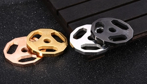 Detail shot of mini barbell plate pendants in rose gold, gold, silver and matte black steel