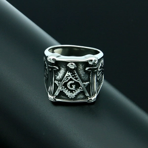 Dettaglio macro di un anello massonico vintage con squadra e compasso su acciaio argento