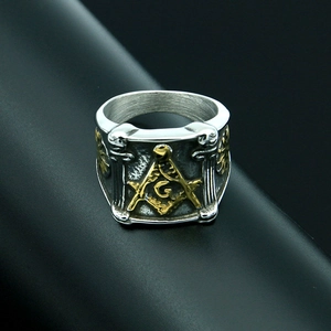 Dettaglio macro dell'anello massonico bicolore argento e oro con squadra e compasso