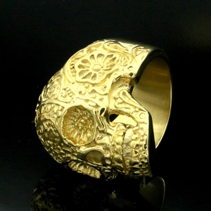 Macro-opname van een gouden schedelring met florale gravures en gepolijste details