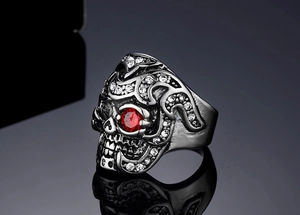 Macro shot of gothic raven skull ring with red ruby eyes and sparkling zircon flame details