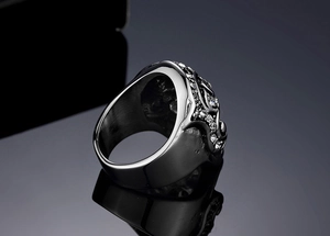 Macro shot of silver-tone skull ring with side carvings and sparkling zircon stones
