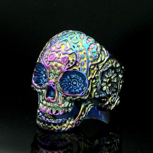 Macro-detail van regenboogkleurige suikerschedel ring met bloemengravure van edelstaal