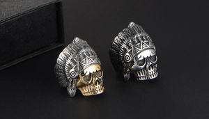 Detail of vintage skull rings with Indian feathered headdresses in silver and gold tone