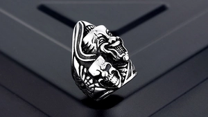 Macro shot of vintage gothic clown mask ring with black silver skull engraving