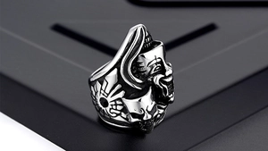 Macro shot of punk style steel ring featuring detailed gothic clown masks and relief texture