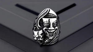 Macro shot of punk gothic crow ring featuring a vintage smiling joker mask detail