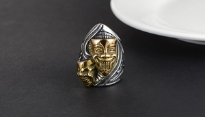Macro shot of gothic raven skull and theatrical mask detail on vintage steel ring
