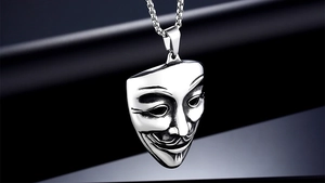 Detailed view of silver Vendetta mask pendant with intricate black facial features