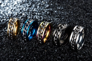 Vista macro de cinco anillos giratorios de colores con cadenas móviles sobre fondo de piedra