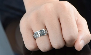 Close-up of vintage steel ring featuring embossed Six-Character Mantra characters
