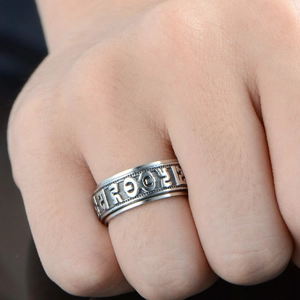 Retro stainless steel rotating ring with Tibetan mantra characters on a hand