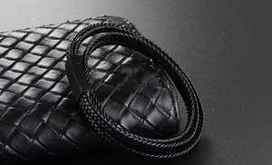 Detail of multi-layer black braided leather bracelet featuring a secure magnetic metal clasp