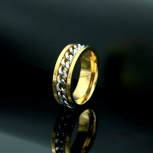 Detalle de anillo giratorio bicolor con cadena de acero sobre fondo negro elegante