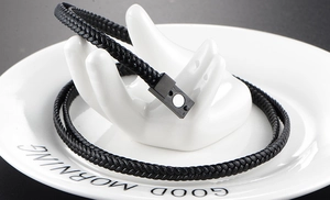 Detail of multi-layer black braided leather bracelet with rectangular magnetic clasp