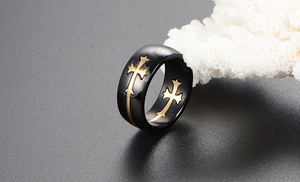 Macro shot of wide black titanium steel ring with engraved golden cross pattern
