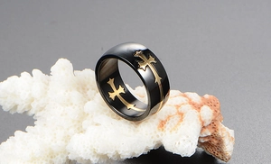 Detail of wide black titanium ring for men with gold religious cross patterns