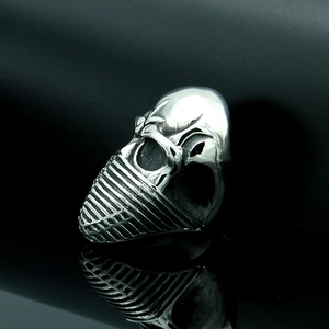 Polished skull ring with American flag mask pattern on black reflective surface