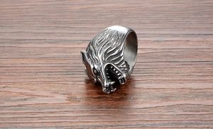 Close-up detail of a punk style wolf head ring in antique silver finish on wood