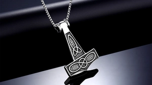 Macro detail of Nordic Thor hammer pendant with Celtic knotwork in antique silver steel
