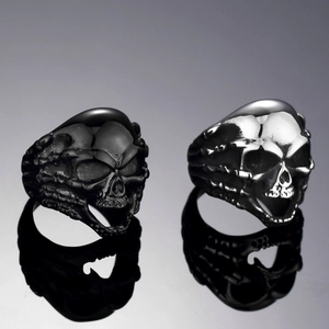 Detalle de anillos de calavera vintage en negro mate y plata pulida con reflejos