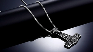 Detailed macro shot of vintage Mjölnir pendant with ram head and Celtic knotwork