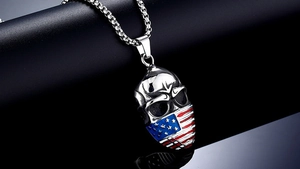 Makroaufnahme vom silbernen Totenkopf Anhänger mit US Flagge aus poliertem Edelstahl