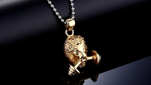 Macro-opname van een gouden leeuwenkop halter hanger met een zilveren kralenketting