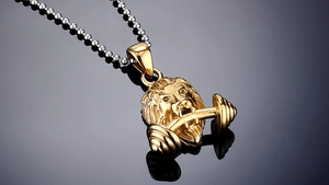 Detailopname van de gouden leeuwenkop hanger met halter op reflecterend zwart oppervlak