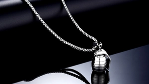 Macro shot of silver grenade pendant with polished stainless steel box chain necklace