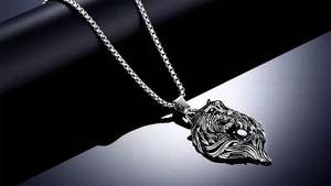 Macro detail of men's titanium steel lion head pendant with black gemstone and box chain