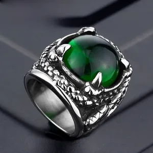 Detailed close-up of a punk dragon claw ring with a large emerald green stone inlay