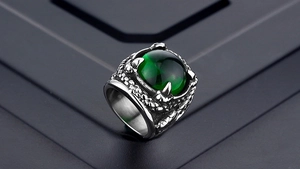 Detailed close-up of a dragon claw ring with a large green gemstone in punk gothic style